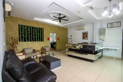 a living room with leather furniture and a ceiling fan at JQ Happy Lumut Hotel in Lumut