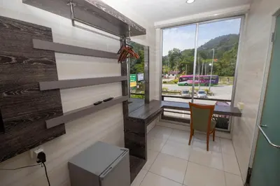 a small room with a table and a window at JQ Happy Lumut Hotel in Lumut