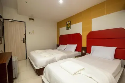 a hotel room with two beds and a television at JQ Happy Lumut Hotel in Lumut