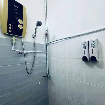 a shower in a bathroom with a phone on the wall at MayiiVip Homestay - Menglembu in Ipoh
