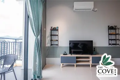a living room with a tv and a table at Ipoh Tambun Waterpark Apartment The Cove Hillside in Ipoh