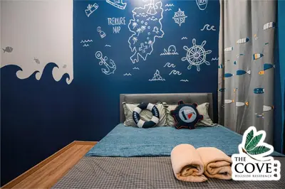 a bedroom with a bed with a blue wall at Ipoh Tambun Waterpark Apartment The Cove Hillside in Ipoh