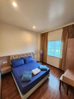 a bedroom with a large bed with blue pillows at Iris Bougainvillea Cameron's in Tanah Rata