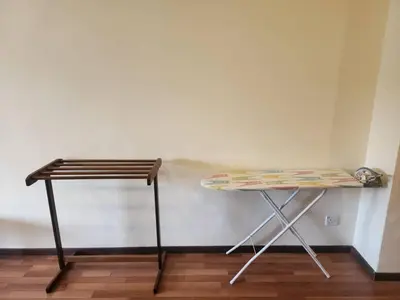 a table and a stool next to a wall at Iris Bougainvillea Cameron's in Tanah Rata