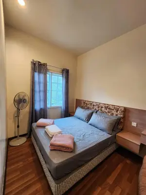 a bedroom with a bed with a fan and a window at Iris Bougainvillea Cameron's in Tanah Rata