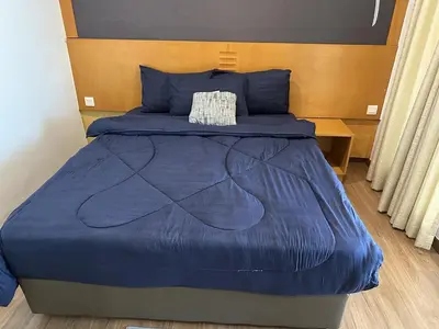 a bed in a room with a blue comforter at 16celsius at Kea Farm Brinchang in Brinchang