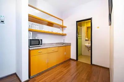 a kitchen with yellow cabinets and a microwave at 16celsius at Kea Farm Brinchang in Brinchang