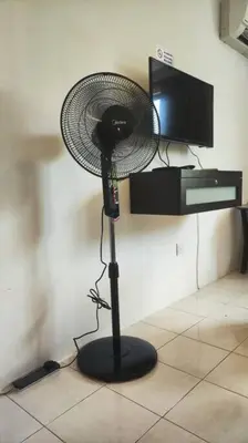 a black fan sitting on a floor in a room at 5 Lot 10 Pangkor Leisure Beach Studio in Pangkor