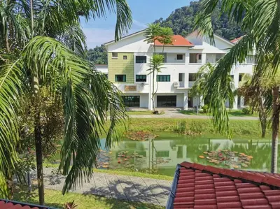 a building with a pond in front of a house at C 23 Lot 10 Pangkor Leisure Beach Studio in Pangkor