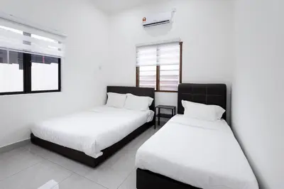two beds in a room with white walls and windows at Dream - Autumn at Pinji Ipoh Town in Ipoh