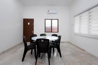 a dining room with a white table and black chairs at Dream - Autumn at Pinji Ipoh Town in Ipoh