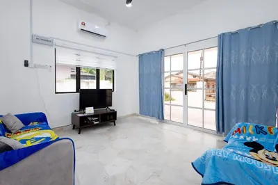 a living room with blue curtains and a tv at Dream - Autumn at Pinji Ipoh Town in Ipoh