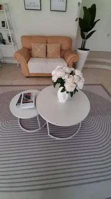 a living room with a table and flowers on a rug at Cozy House in Taiping in Taiping