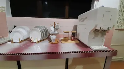 a counter with a sewing machine and dishes on it at Cozy House in Taiping in Taiping