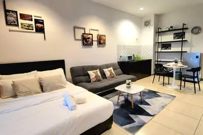 a bedroom with a bed and a couch and a table at Ipoh City Centre 八角楼 OCTAGON Homestay - 2 mins walking to famous food & 15 mins to Old Town Ipoh by Happy Homestay in Ipoh