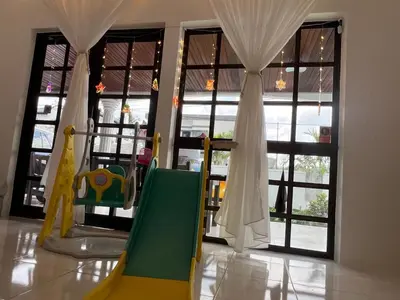 a room with a play room with chairs and windows at C&C Villa Pool Ipoh in Ipoh