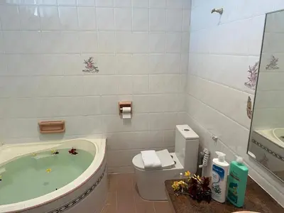 a bathroom with a tub and a toilet and a sink at C&C Villa Pool Ipoh in Ipoh