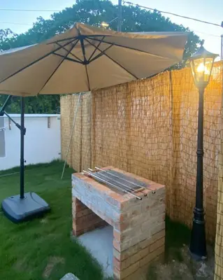 an umbrella and a bench with a light at C&C Villa Pool Ipoh in Ipoh