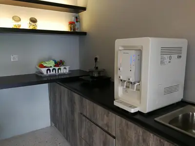 a microwave sitting on a kitchen counter with a sink at Check-Inn Guesthouse in Ipoh
