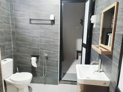 a bathroom with a toilet and a sink and a shower at IPOH MENGLEMBU LOHAS 4BR3Bath14 PAX in Ipoh