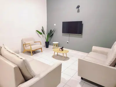 a living room with a couch and a tv at IPOH MENGLEMBU LOHAS 4BR3Bath14 PAX in Ipoh