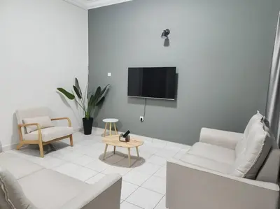 a living room with a couch and a tv at IPOH MENGLEMBU LOHAS 4BR3Bath14 PAX in Ipoh