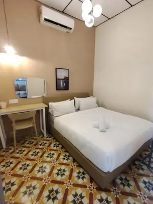 a hotel room with a bed and a desk and a bed at Georgetown Guest House 37 in George Town