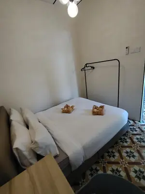 a bedroom with a bed with two cats on it at Georgetown Guest House 37 in George Town
