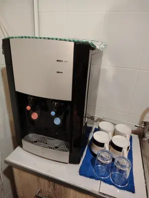 a microwave sitting on a counter with four cups at Georgetown Guest House 37 in George Town