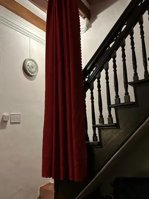 a staircase with a red curtain and a clock on the wall at The Gaslight Heritage Residence - NEW in George Town