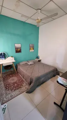 a bedroom with a bed and a blue wall at MAR Homestay Seri Iskandar in Seri Iskandar