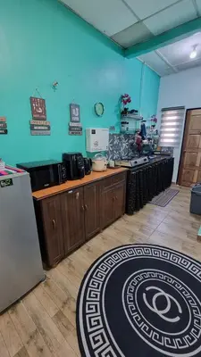 a kitchen with wooden counters and a blue wall at MAR Homestay Seri Iskandar in Seri Iskandar