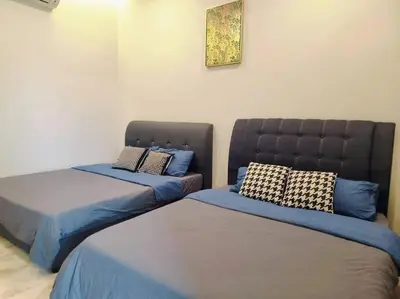two beds in a room with blue sheets and pillows at 10Min to IPOH TOWN 4BR20PAX MAHJONG GAME KARAOK in Ipoh