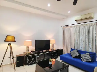 a living room with a blue couch and a tv at 10min to IPOH town GEMILANG TAWAS 4br4bath 14pax in Ipoh
