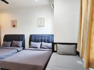 a living room with two beds and a couch at 10min to IPOH TOWN gunung lang 4br4bath 14 pax in Ipoh