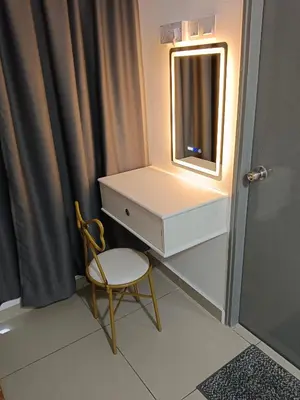 a bathroom with a dresser and a chair and a mirror at Happy Homestay TheVenus Sitiawan in Sitiawan