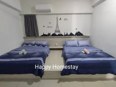 two beds in a room with a picture of the eiffel tower at Happy Homestay TheVenus Sitiawan in Sitiawan