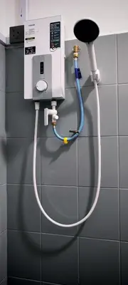a water hose hooked up to a machine on a wall at 23 Inn Singlebed Share Bathroom No Window in Bukit Mertajam