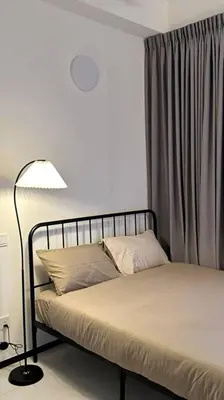 a bedroom with a bed with a lamp and a curtain at URBAN Georgetown 9Pax 4QueenBed 3Bedroom 2Bath 2carparks in Jelutong