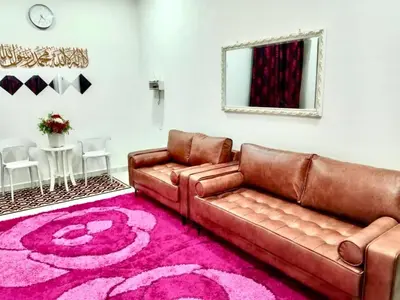 a living room with a brown leather couch and a pink rug at Homestay Arora Teluk Intan in Teluk Intan