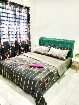 a bed with a green headboard in a bedroom at Homestay Arora Teluk Intan in Teluk Intan