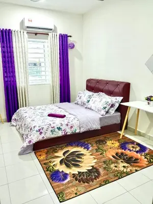 a bedroom with a bed with purple curtains and a rug at Homestay Arora Teluk Intan in Teluk Intan