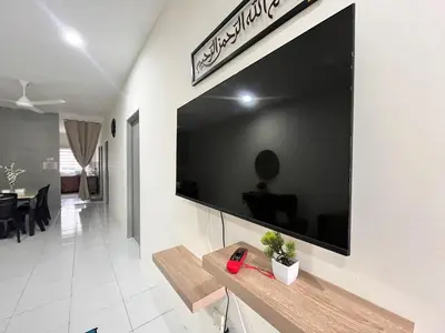 a large flat screen tv on a wall in a living room at Mama Zan Homestay in Seri Iskandar