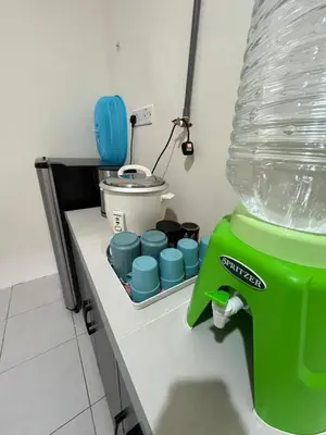 a green blender sitting on a counter in a kitchen at Mama Zan Homestay in Seri Iskandar