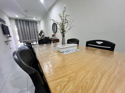 a dining room with a wooden table and black chairs at Mama Zan Homestay in Seri Iskandar