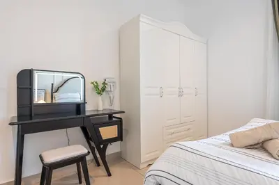 a bedroom with a bed and a desk with a mirror at Serene French Family Retreat with Sunrise View in Cameron Highlands