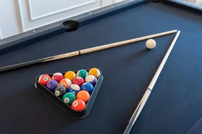a container of billiard balls and cues on a pool table at Serene French Family Retreat with Sunrise View in Cameron Highlands