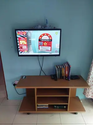 a flat screen tv on a wall with a wooden table at Jerai Geopark Cottage Alamanda in Baling