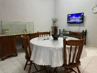 a dining room with a table and a fish tank at HOMESTAY Sg Petani in Sungai Petani