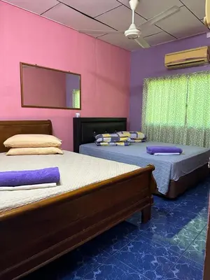 two beds in a room with purple walls at HOMESTAY Sg Petani in Sungai Petani